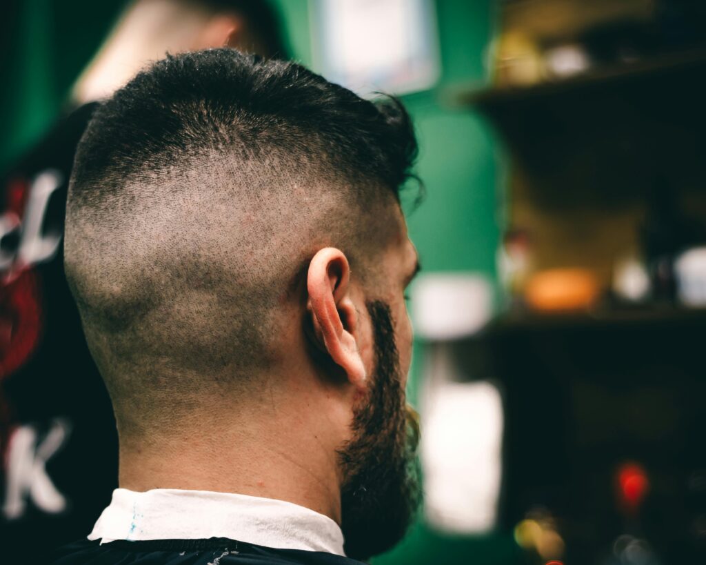 Rear view close-up of a man with a fresh haircut at a barbershop, showcasing a sharp fade.